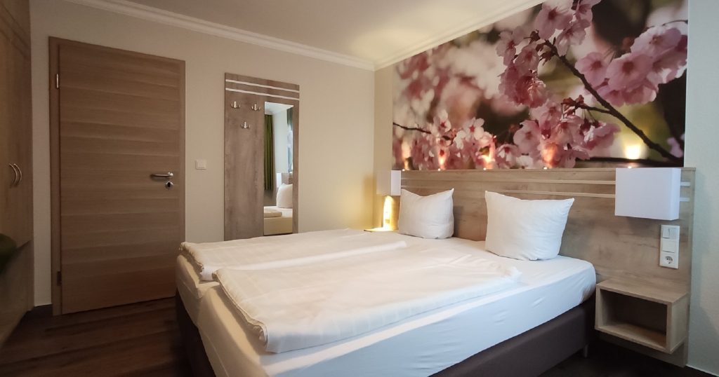 schöne Hotelzimmereinrichtung in hellem Holz mit Fototapete über dem Bett